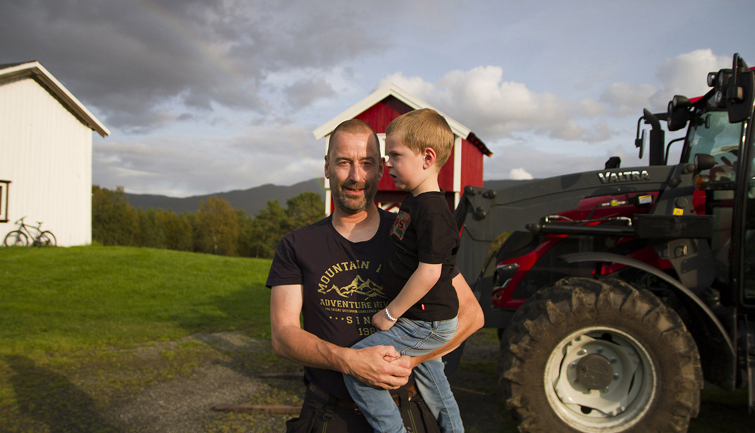 Rune Morten Myrhaug og sønnen Ola foran Valtra-traktoren de bruker til å produsere ved.