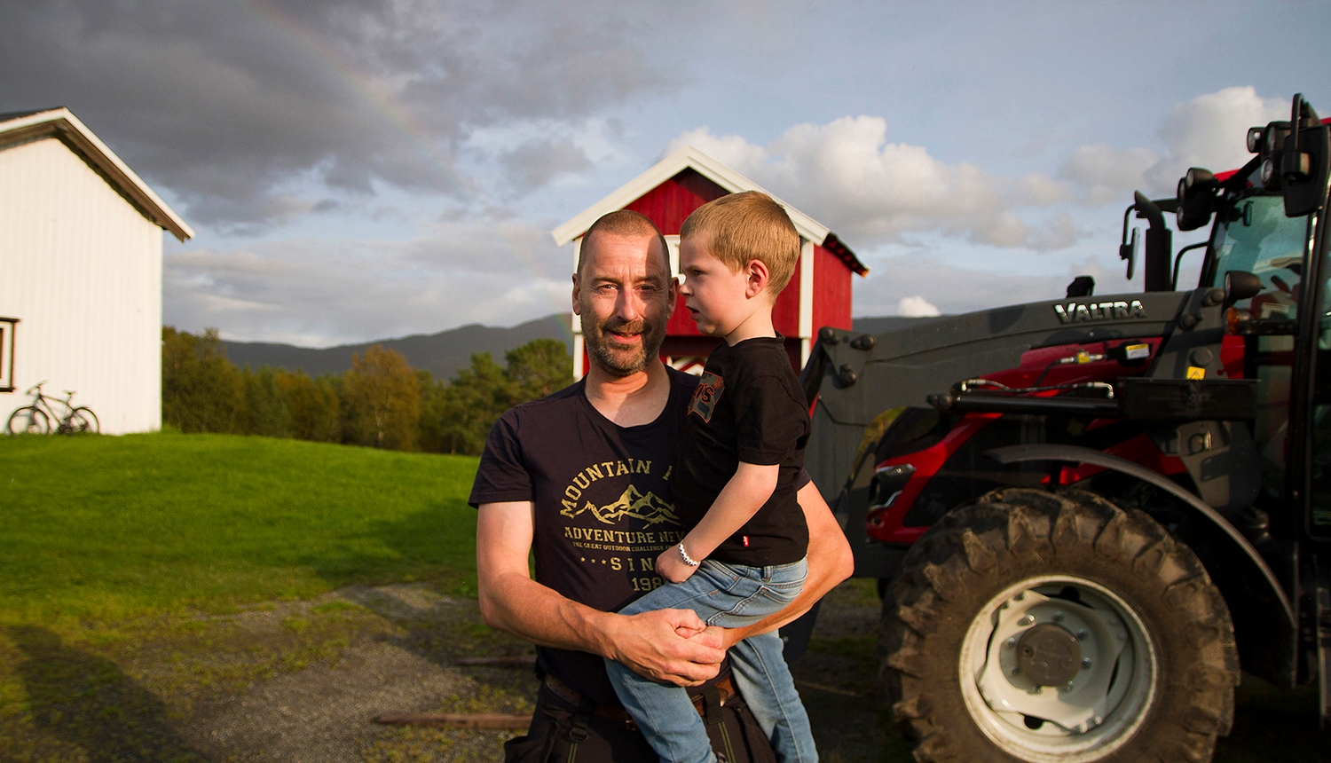 Rune Morten Myrhaug og sønnen Ola foran Valtra-traktoren de bruker til å produsere ved.